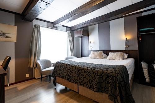 um quarto com uma cama grande e uma janela em Hotel Zeezicht em Harlingen