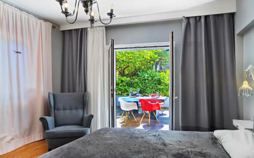 um quarto com uma cama, uma cadeira e uma mesa em Five Seasons Alimos em Atenas