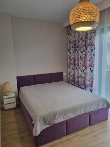 a bedroom with a purple bed with a curtain at Sosnówkowy Zakątek in Sosnówka