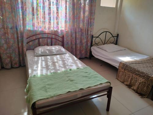 a small room with two beds and a window at THE TAJ Inn in Cagayan de Oro