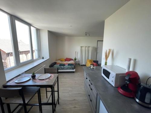 - un salon avec une table et un four micro-ondes dans l'établissement Studio Cosy 3 proche gare, à Saint-Quentin