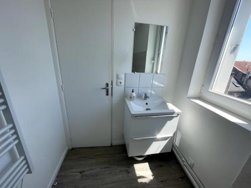 une salle de bain blanche avec un lavabo et un miroir dans l'établissement Studio Cosy 3 proche gare, à Saint-Quentin