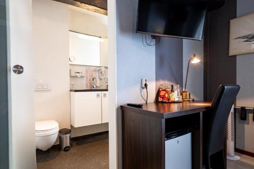 een kleine badkamer met een toilet en een wastafel bij Hotel Zeezicht in Harlingen