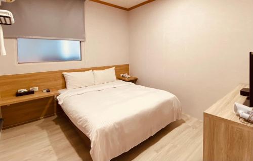 a bedroom with a white bed and a window at Beauty Garden Hotel - Jiaoxi in Jiaoxi
