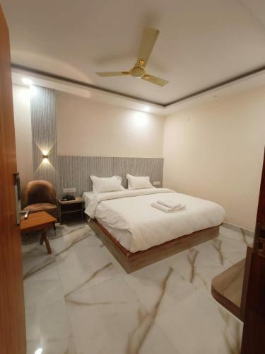 una camera con un grande letto e una sedia di Hotel GD Grand Inn a Gorakhpur