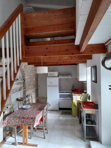 une cuisine avec une table et une salle à manger dans l'établissement maison Treille, à Sainte-Marie de Ré