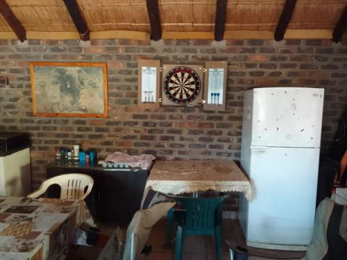 a kitchen with a refrigerator and a dartboard on the wall at Buffalo Street Cottages in Malelane