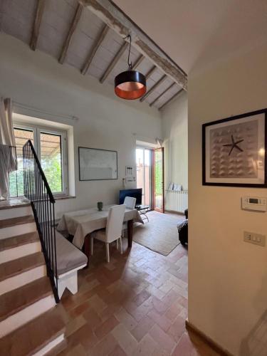 a living room with a staircase and a table at Le case di Anita in Toscana -Capalbio in Capalbio