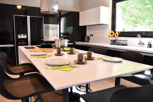 a kitchen with a white table and black cabinets at Terra Nova Luxury Villa in Mystras