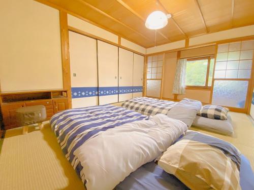 1 dormitorio con 2 camas y ventana en 【1棟貸切】奈良公園から車で約12分　近隣ゴルフ場迄車で約8分　送迎車有り, 