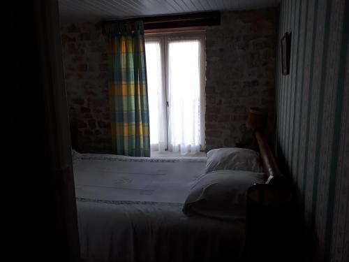 - une chambre avec un lit et une fenêtre avec un rideau arc-en-ciel dans l'établissement maison grange, à Sainte-Marie de Ré