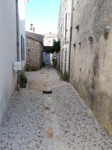 Une allée dans une ruelle entre deux bâtiments dans l'établissement maison grange, à Sainte-Marie de Ré