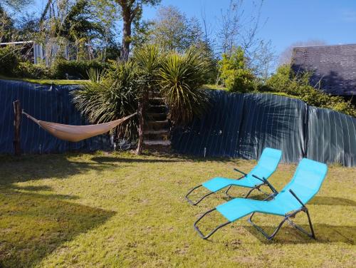 two chairs and a hammock in a yard at Jolie maison au calme et proche mer avec spa en option in Saint-Germain-le-Gaillard