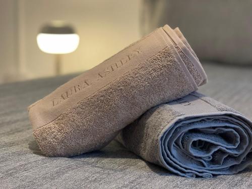 a rolled up towel on a bed with a measuring tape at Luxury,Location and Convenience in Bournemouth