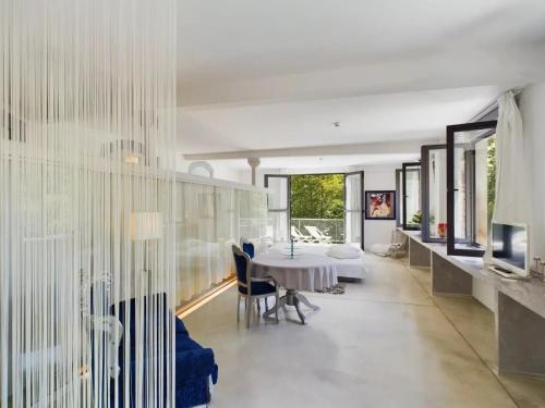 une salle à manger avec une table et des chaises blanches dans l'établissement La manufacture, à Antraigues-sur-Volane