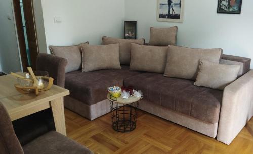 a living room with a couch and a table at PremiumPlus Apartman in Vrnjačka Banja
