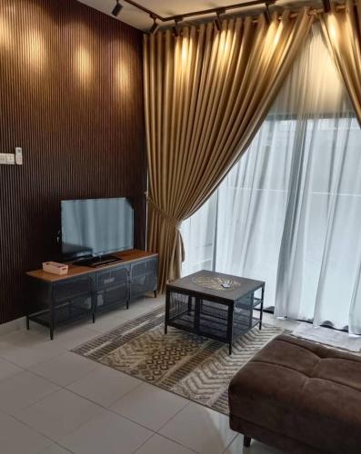 a living room with a flat screen tv and a couch at youth city residence in Nilai