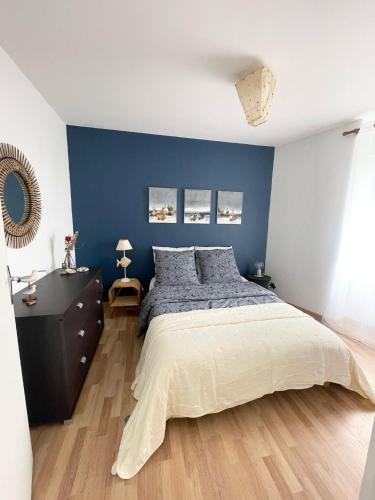 - une chambre avec un mur bleu et un lit dans l'établissement Escale à Ploumanac'h, à Perros-Guirec
