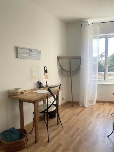 Cette chambre comprend un bureau, une table et une fenêtre. dans l'établissement Escale à Ploumanac'h, à Perros-Guirec