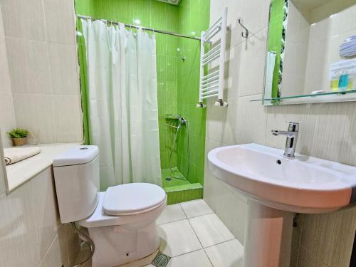 a bathroom with a toilet and a sink and a shower at Hotel Magdalena in Mtskheta