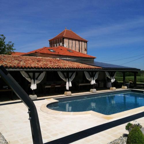 a house with a swimming pool next to a building at Chambres Rozies Dunes in Dunes