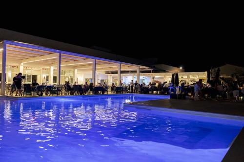 a swimming pool at night with people in a building at HOTEL CRISTALLO PAESTUM in Capaccio-Paestum