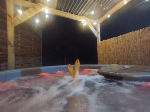a hot tub filled with water with bananas in it at Jolie maison au calme et proche mer avec spa en option in Saint-Germain-le-Gaillard