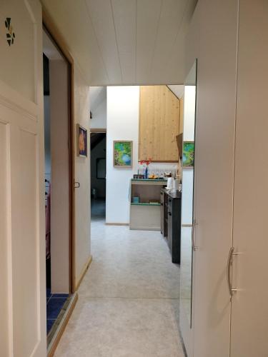 a hallway leading to a kitchen with a door open at BnB LES OISEAUX, chez Lidia, 26m2 à 44m2, 2ème étage in Vendlincourt