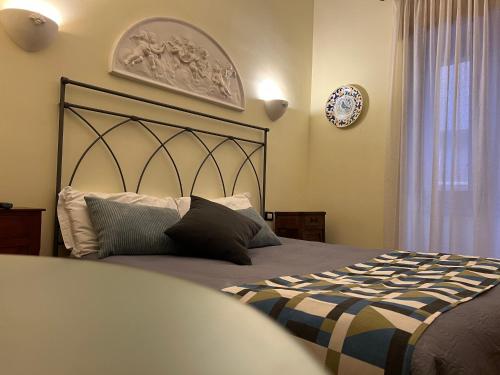 a bedroom with a bed and a clock on the wall at La foresteria in Agrigento