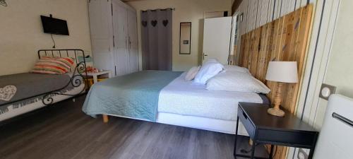 a bedroom with a bed and a table with a lamp at Chambre d'hôte La Voilerie du Cher in Saint-Georges-sur-Cher