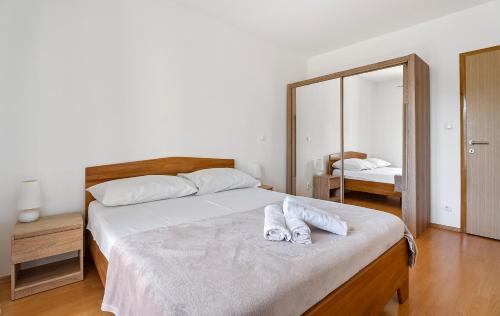a bedroom with a bed with two towels on it at Modern apartment with private pool near Split in Podstrana