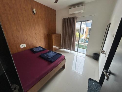 a bedroom with a bed in a room with a window at HemPriya - 3BHK wit a Private Pool in Lonavala