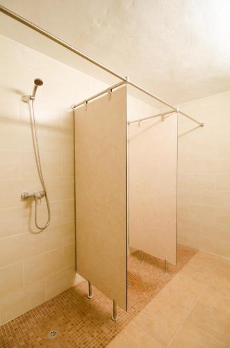 a shower stall with a glass door in a bathroom at Embat - Hostel in Montuiri