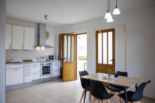 kuchnia z drewnianym stołem, stołem i krzesłami w obiekcie Anesis Apartments w miejscowości Agia Marina