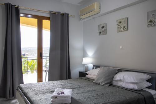sypialnia z łóżkiem i oknem z balkonem w obiekcie Anesis Apartments w miejscowości Agia Marina