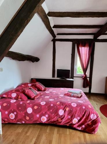 une chambre avec un lit rose à pois dans l'établissement Maison normande avec piscine chauffée privée, à La Croupte