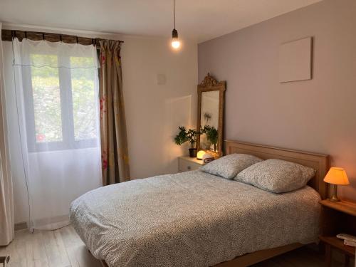 a bedroom with a bed and a mirror and a window at Périgourdine avec spa et vue in Pomport