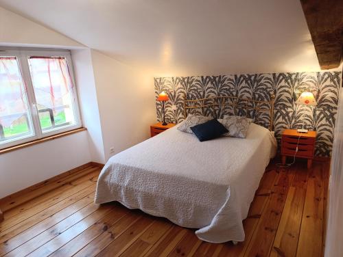 Un dormitorio con una cama grande y una pared en Gîtes de la Bibudière en Le Boupère