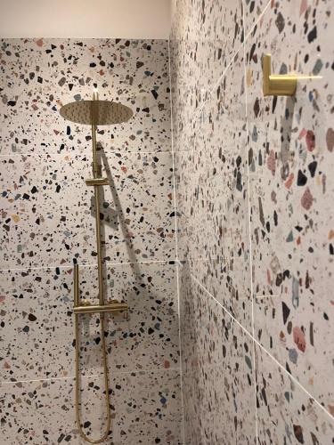La salle de bains est pourvue d'une douche et d'un mur fleuri. dans l'établissement Le petit toulousain chic, à Toulouse