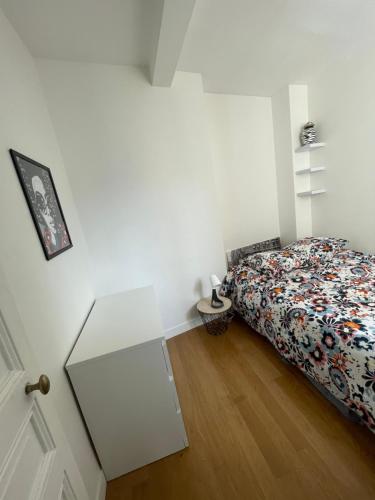 een slaapkamer met een bed en een witte tafel bij Parisian charm flats in Levallois-Perret