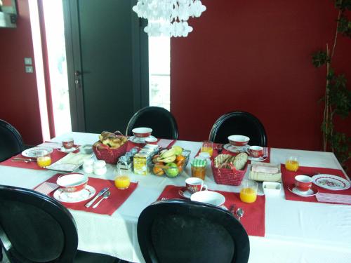 - une table blanche avec de la nourriture et des chaises noires dans l'établissement Maison d'Hôtes Côté Cour, à Rasteau