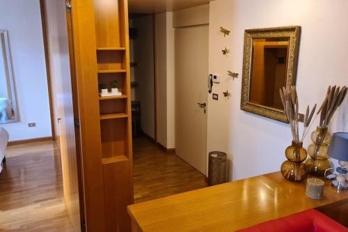 um quarto com uma mesa e um espelho e um corredor em Il Nido di legno em Udine