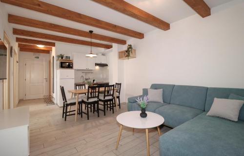 ein Wohnzimmer mit einem blauen Sofa und einem Tisch in der Unterkunft Laura Apartments in Brodarica