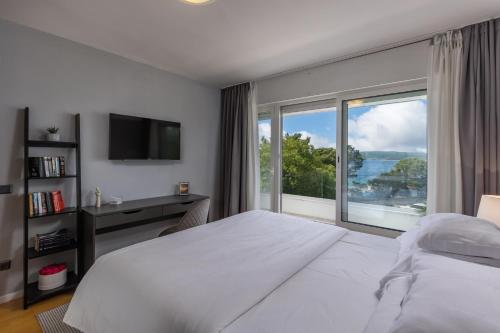 a bedroom with a large bed and a large window at Apartments Sax in Crikvenica
