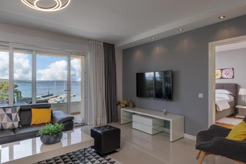 a living room with a couch and a bed and a television at Apartments Sax in Crikvenica
