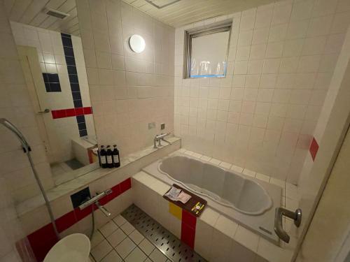 a bathroom with a tub and a toilet at Hotel Luxe - Adult Only in Tokyo