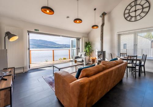 a living room with a couch and a large window at Shoreland Lodges - Holly Lodge in Fort Augustus