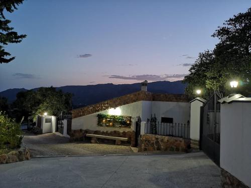 una casa con un banco en una entrada de noche en Apartamentos Turísticos Rurales ENTRESIERRAS, en Cazorla