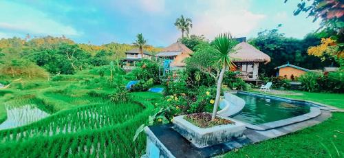 a house with a swimming pool and a garden at Pondok Apsari 2 in Singaraja