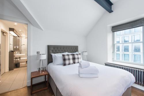 a bedroom with a large white bed and a window at Cool urban apartment with stunning Castle views in Edinburgh